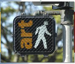 Close-up of a pedestrian traffic light with the word "art" in yellow vertical text overlapping the traditional white walking figure.