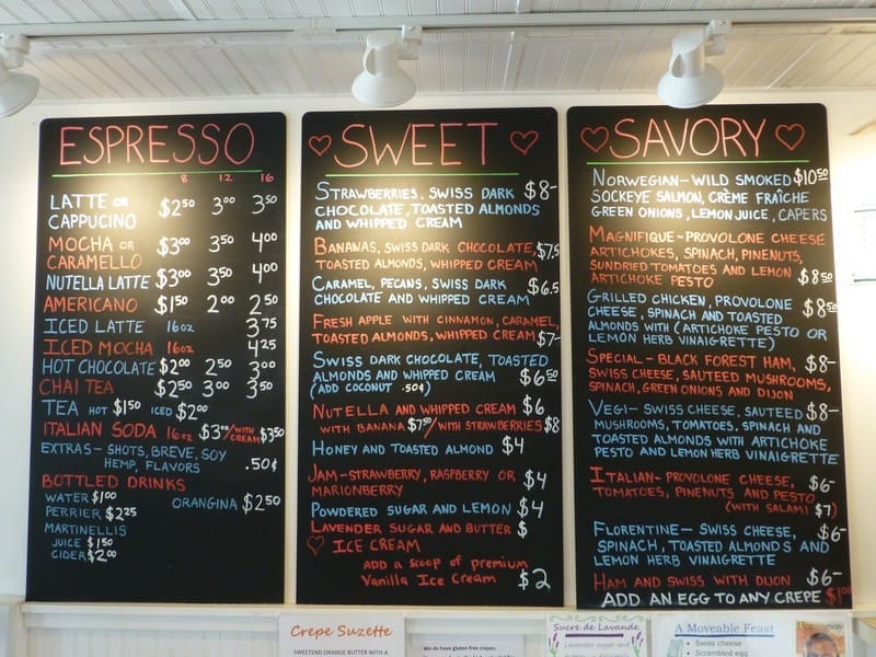 A menu displayed on three blackboards listing various coffee, sweet, and savory options with prices. The categories are titled "Espresso," "Sweet," and "Savory.