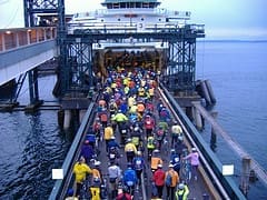 Cyclists board a ferry at a dock.