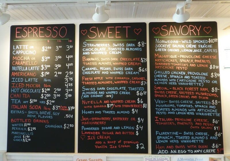 A menu displayed on three blackboards listing various coffee, sweet, and savory options with prices. The categories are titled "Espresso," "Sweet," and "Savory.