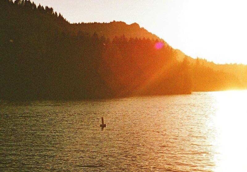 Sunset over a lake with a buoy.