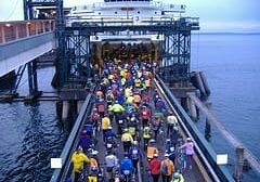 Cyclists board a ferry at a dock.