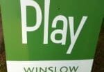 A green and white sign that reads "Play" at the top and "Winslow" at the bottom.