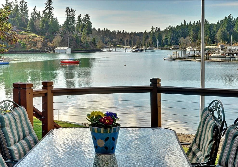 Waterfront patio with flowers and a view.